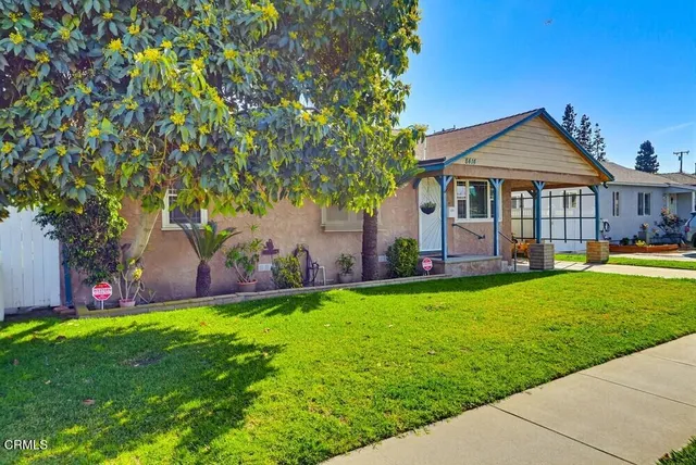 a view of a house with a yard and a tree
