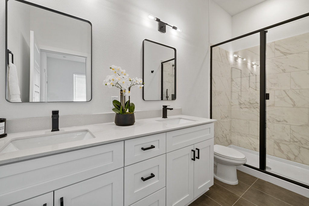 1811 Webberville Road, Unit 1209 Austin, TX 78721 - Photo 10 of 35 a bathroom with double sink a toilet a shower and a mirror