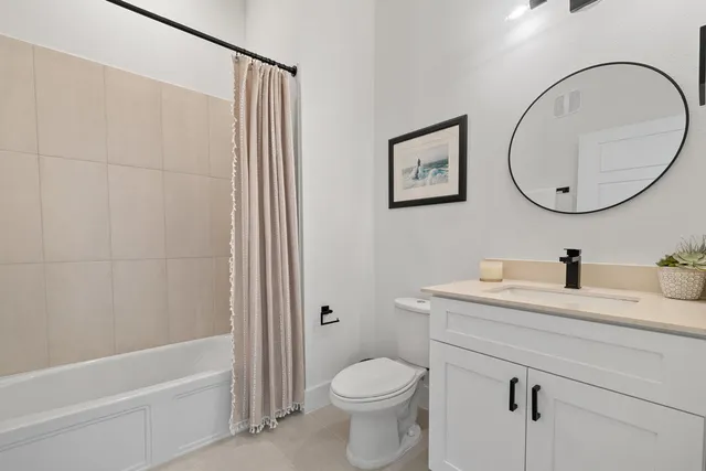 a bathroom with a granite countertop toilet sink and mirror