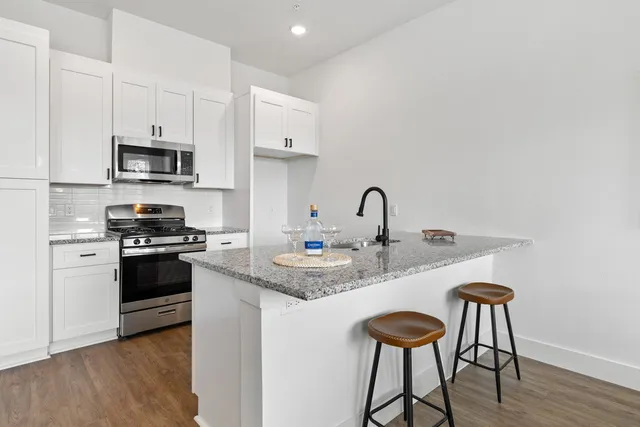 a kitchen with stainless steel appliances granite countertop a stove a sink and a refrigerator