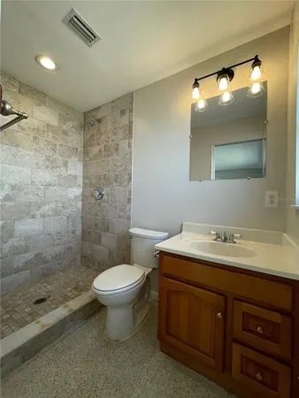 a bathroom with a sink a toilet and shower