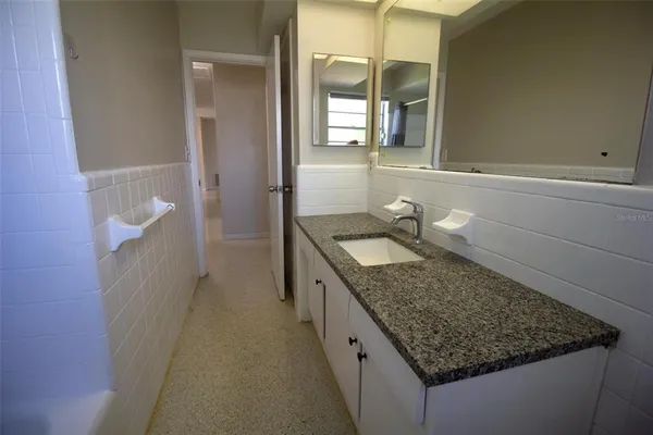 a bathroom with a granite countertop sink and a mirror