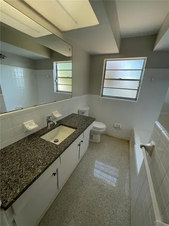 a spacious bathroom with a granite countertop tub sink and mirror
