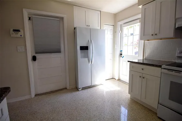 a view of a kitchen with a refrigerator cabinets and a window