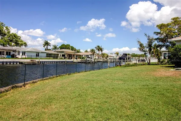 a view of a swimming pool with a lawn chairs and a big yard