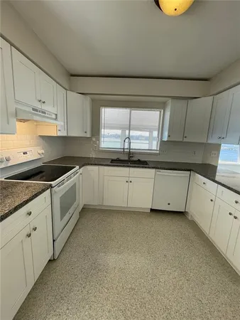 a large kitchen with white cabinets