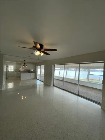 en empty room with windows and ceiling fan