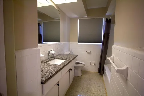 a bathroom with a granite countertop sink toilet and shower