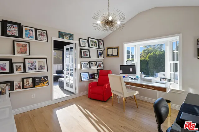 a bedroom with a bed and a flat tv screen on dresser