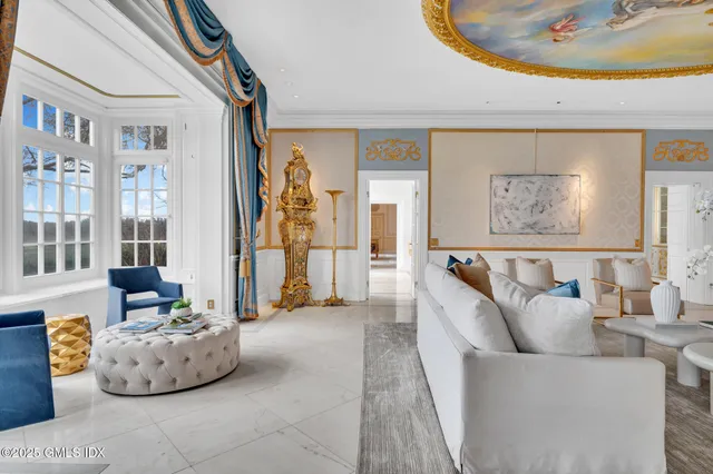 a living room with couches a table and chairs with wooden floor