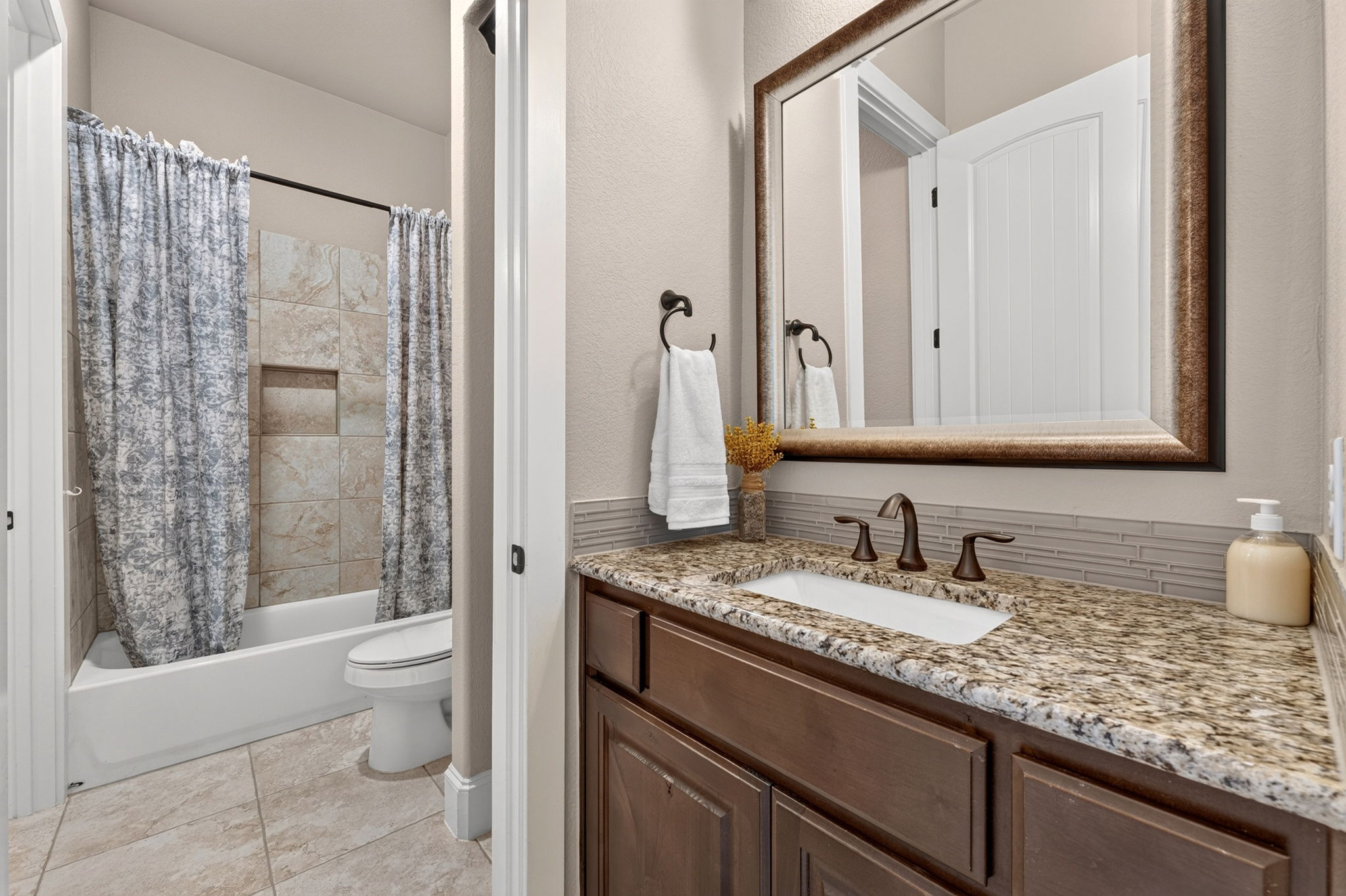 105 Coopers Hill Road Georgetown, TX 78633 - Photo 28 of 40 a bathroom with a granite countertop sink a toilet a mirror and shower