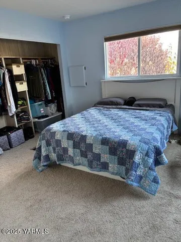 a view of walk in closet with window and shower