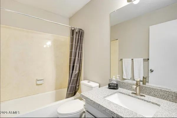 a bathroom with a granite countertop sink toilet and shower