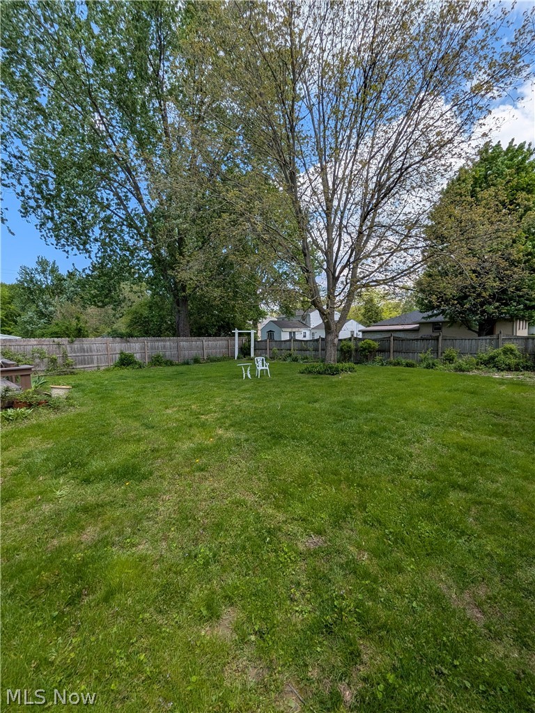 1161 Gulf Road Elyria, OH 44035 - Photo 6 of 34 Expansive green lawn with mature trees and a wood privacy fence
