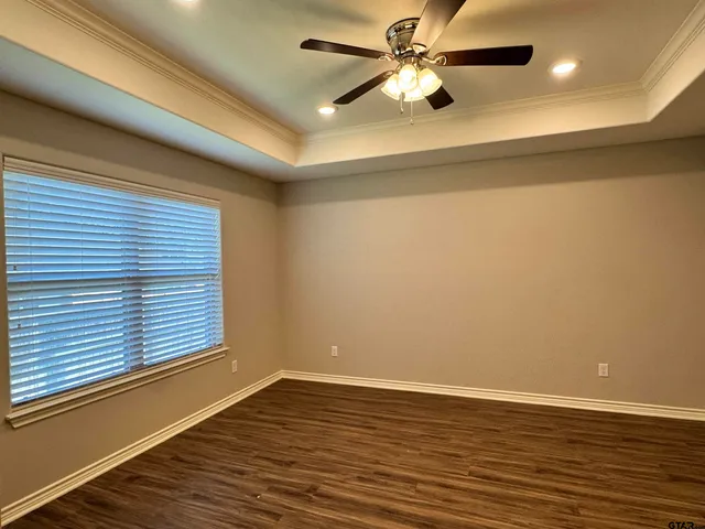 a view of a room with wooden floor and a ceiling fan