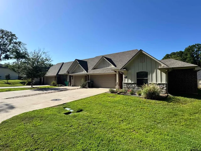 a front view of a house with yard and green space