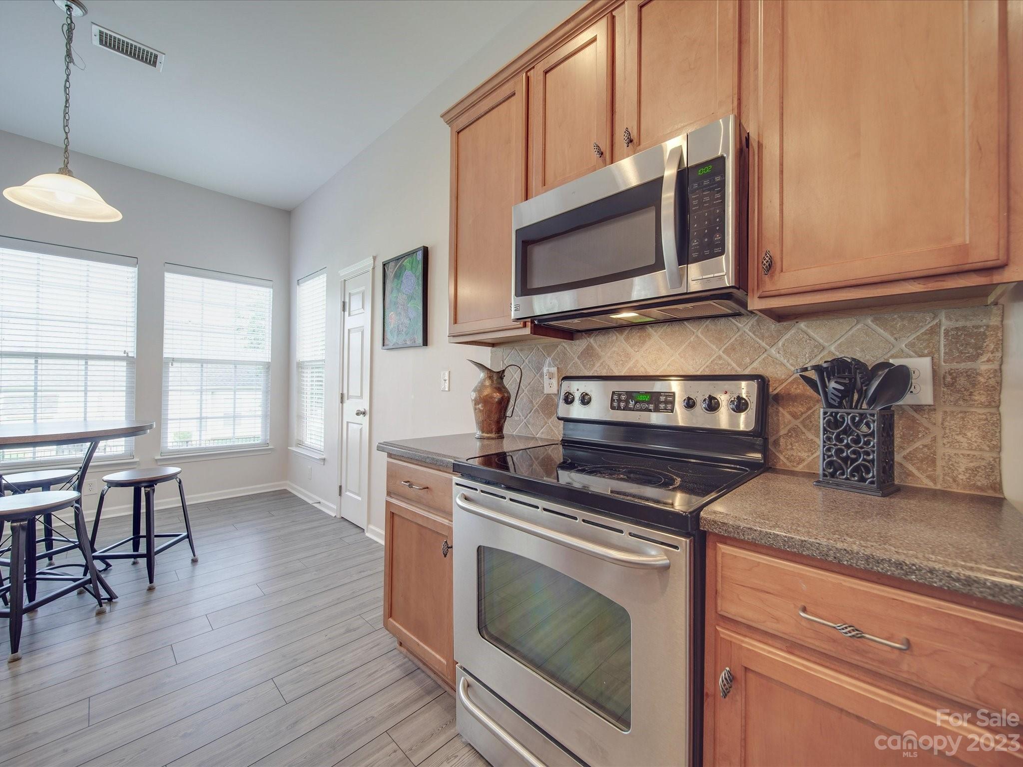10102 Trailmoor Road Charlotte, NC 28278 - Photo 14 of 44 a kitchen with stainless steel appliances a stove microwave and cabinets