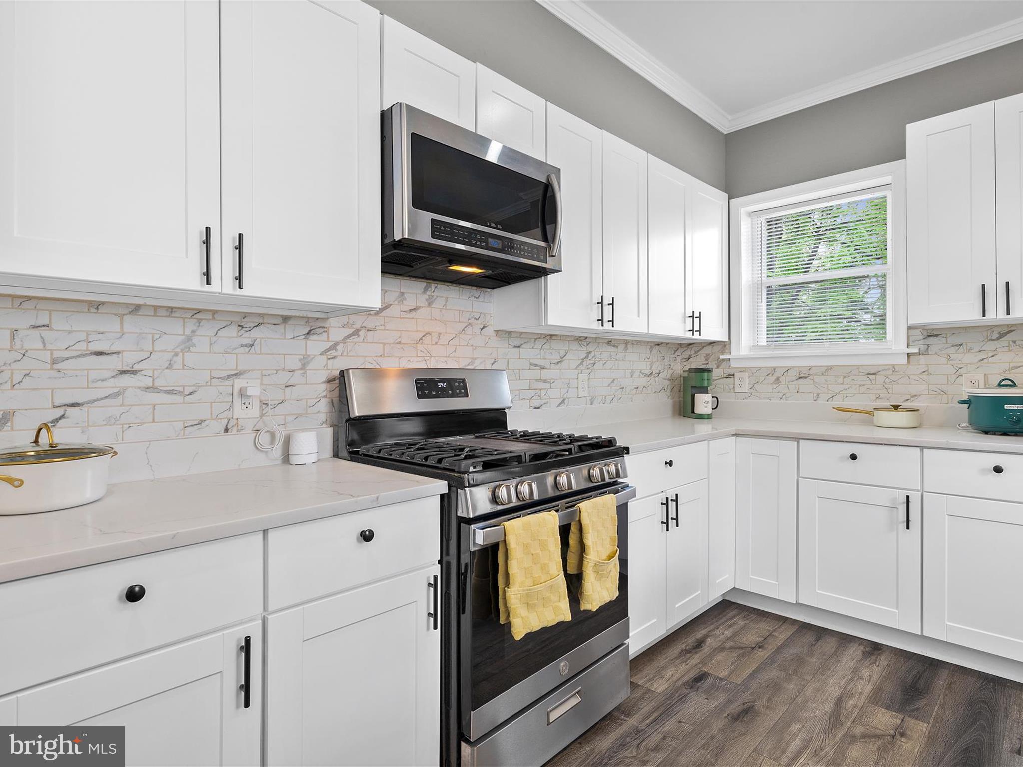 3032 Chelsea Terrace Baltimore, MD 21216 - Photo 12 of 29 a kitchen with stainless steel appliances white cabinets granite counter tops and a wooden floors