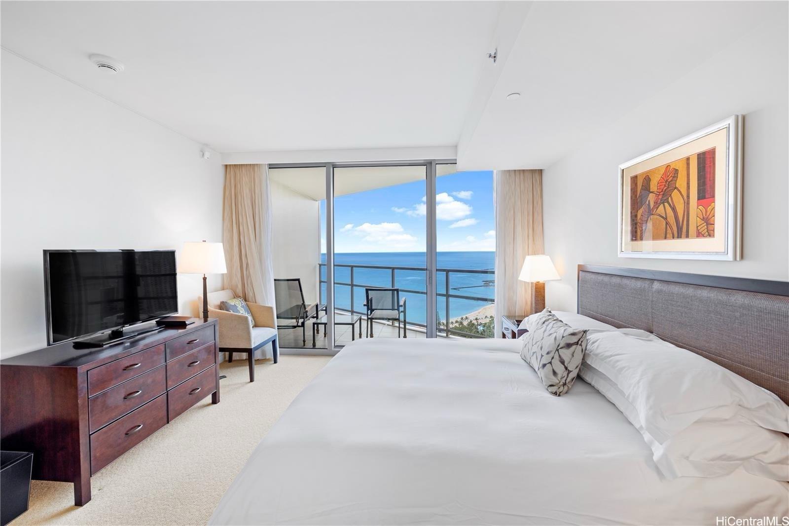 223 Saratoga Road, Unit 3203 Honolulu, HI 96815 - Photo 13 of 24 a bedroom with a bed and a flat tv screen on dresser