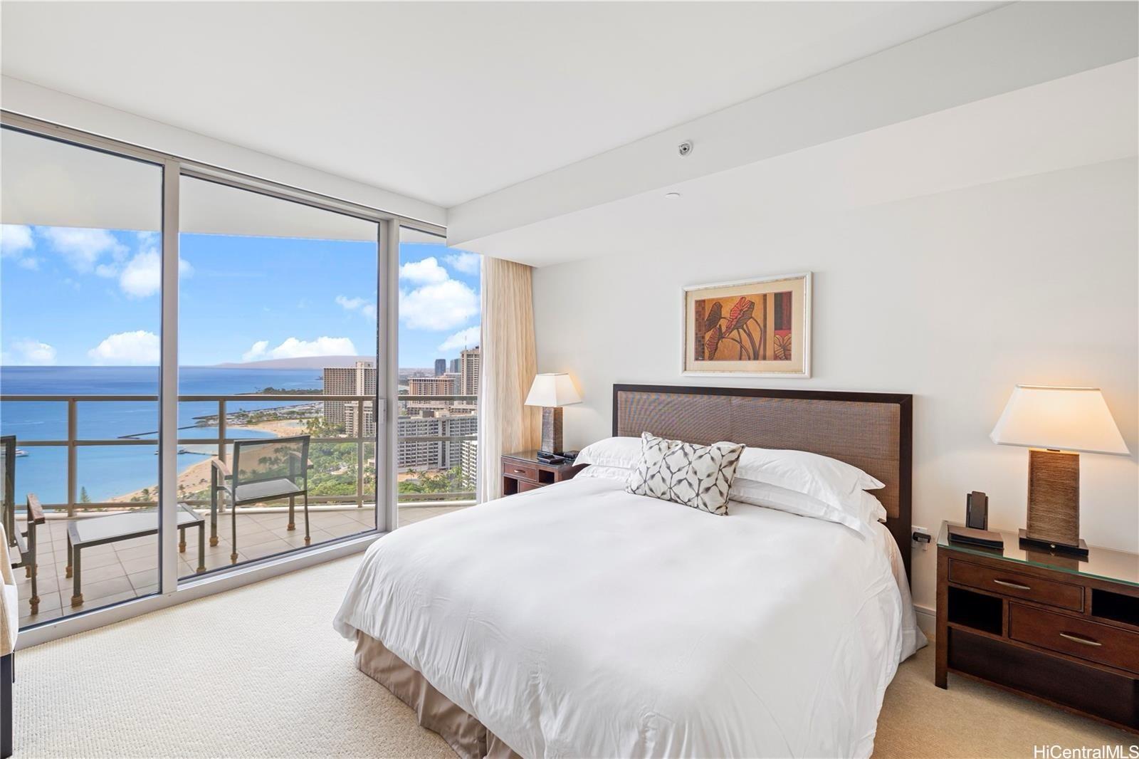 223 Saratoga Road, Unit 3203 Honolulu, HI 96815 - Photo 14 of 24 a bedroom with a large bed and a lamp