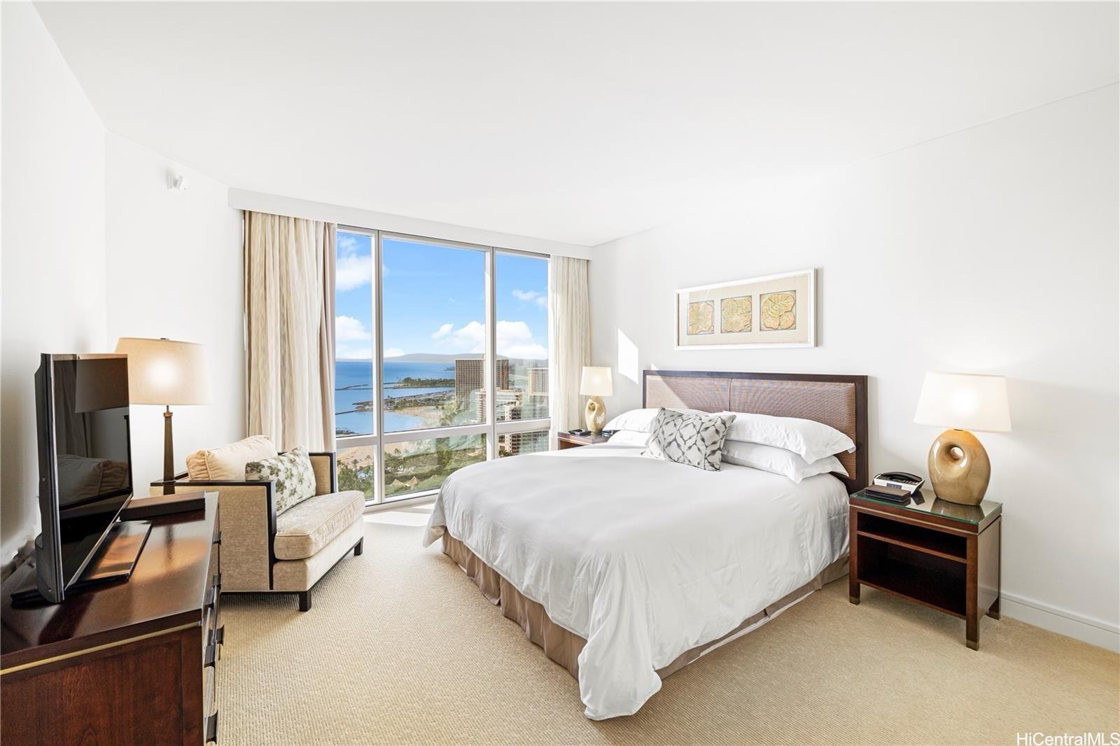 223 Saratoga Road, Unit 3203 Honolulu, HI 96815 - Photo 19 of 24 a bedroom with a bed and a flat screen tv