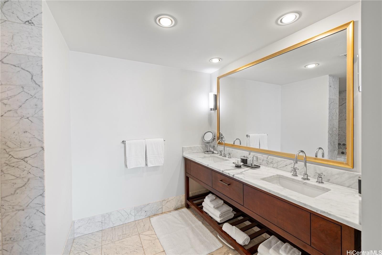 223 Saratoga Road, Unit 3203 Honolulu, HI 96815 - Photo 23 of 24 a bathroom with a double vanity sink and a mirror