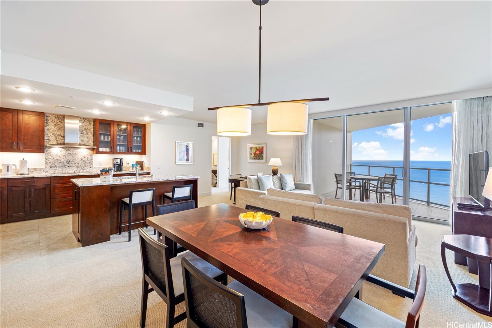 223 Saratoga Road, Unit 3203 Honolulu, HI 96815 - Photo 3 of 24 a dining room with a table chairs and kitchen view