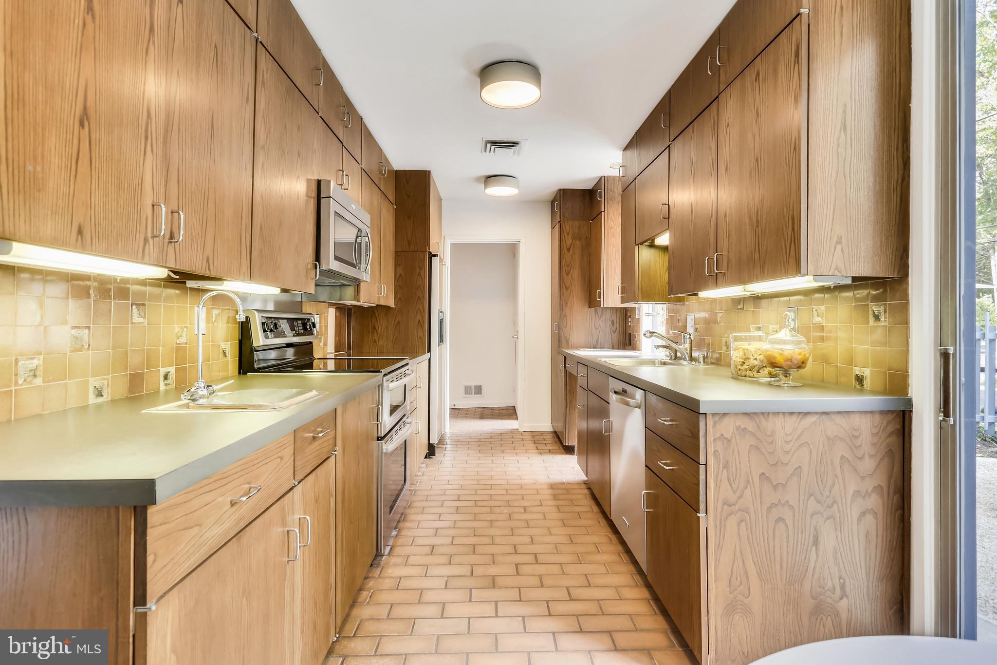 3928 Rickover Road Silver Spring, MD 20902 - Photo 14 of 62 a large kitchen with a large counter top a sink stainless steel appliances and cabinets