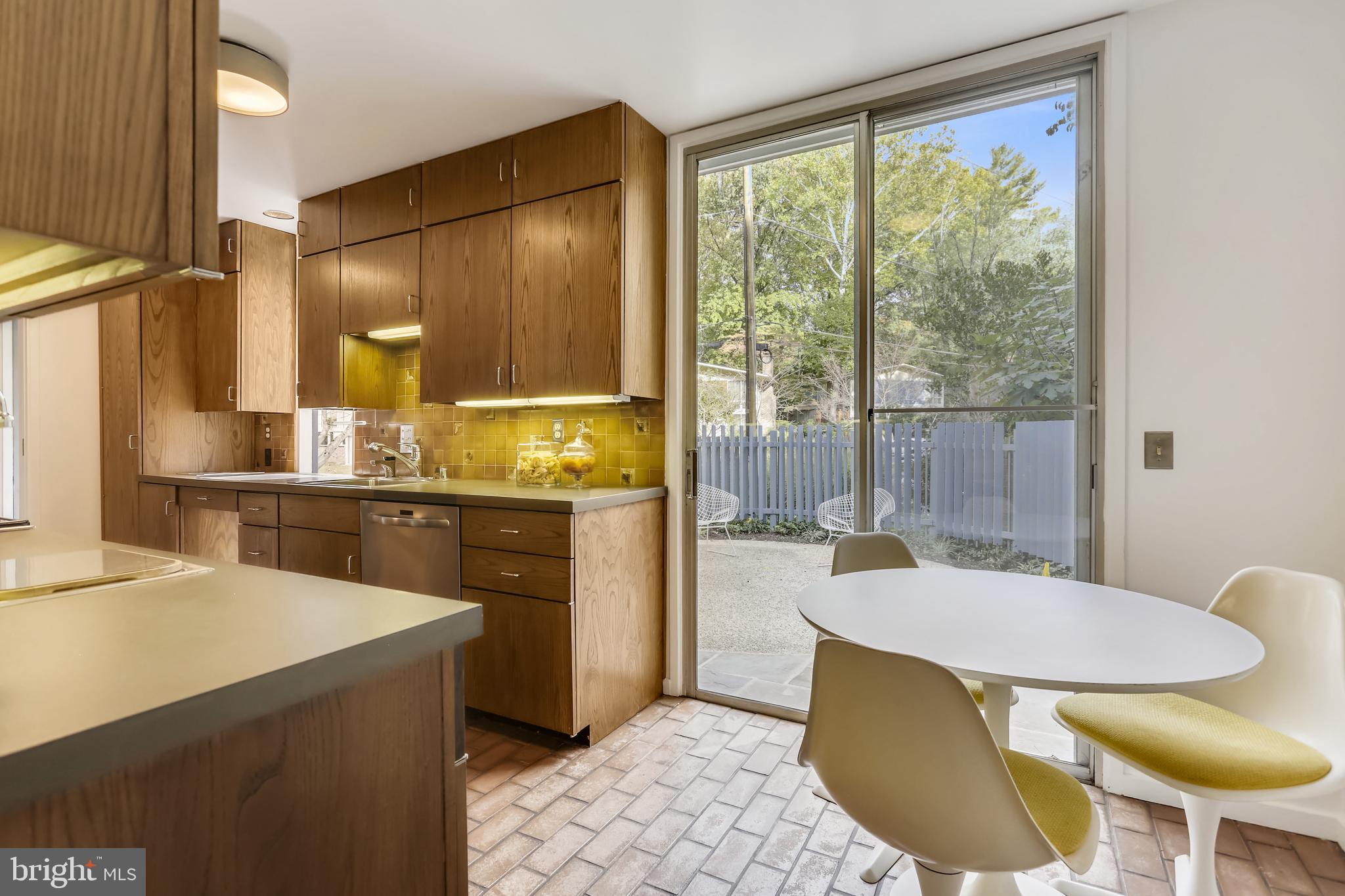 3928 Rickover Road Silver Spring, MD 20902 - Photo 15 of 62 a kitchen with a table chairs and a refrigerator