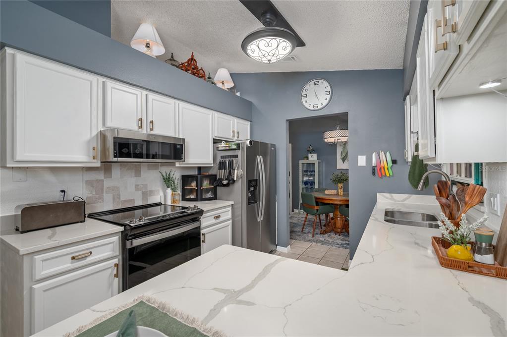 22 Rosedown Boulevard DeBary, FL 32713 - Photo 4 of 31 a kitchen with stainless steel appliances granite countertop a refrigerator a stove and a sink with dishwasher