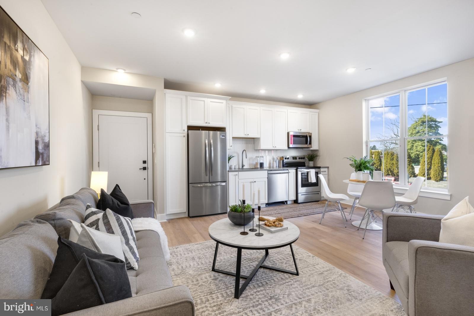 a living room with furniture and kitchen view
