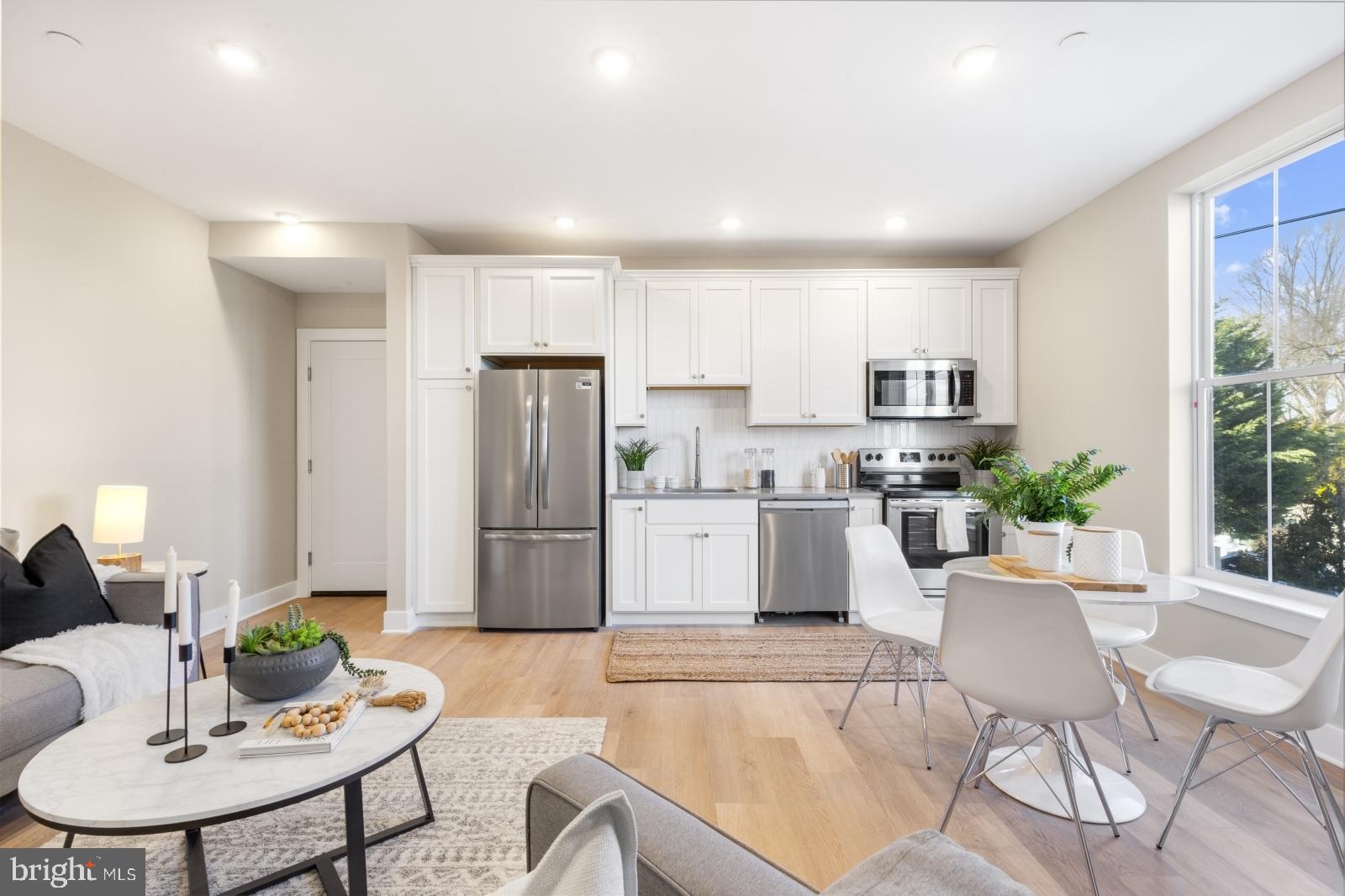 6712 Ridge Avenue, Unit 302 Philadelphia, PA 19128 - Photo 11 of 22 a kitchen with white cabinets stainless steel appliances and dining table
