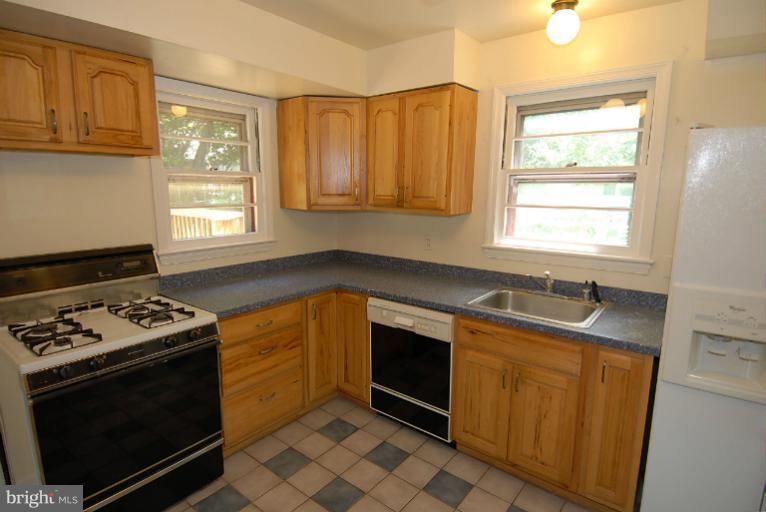 12003 Lafayette Court Silver Spring, MD 20902 - Photo 6 of 22 a kitchen with granite countertop a sink stove and cabinets