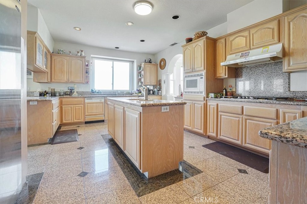 13097 Sage Hen Road Victorville, CA 92395 - Photo 37 of 63 a kitchen with stainless steel appliances granite countertop a stove top oven sink and cabinets