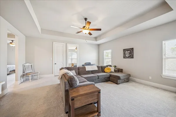 a bedroom with bed and a chandelier fan