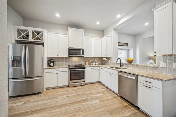 a view of a hallway with wooden floor and a bathroom