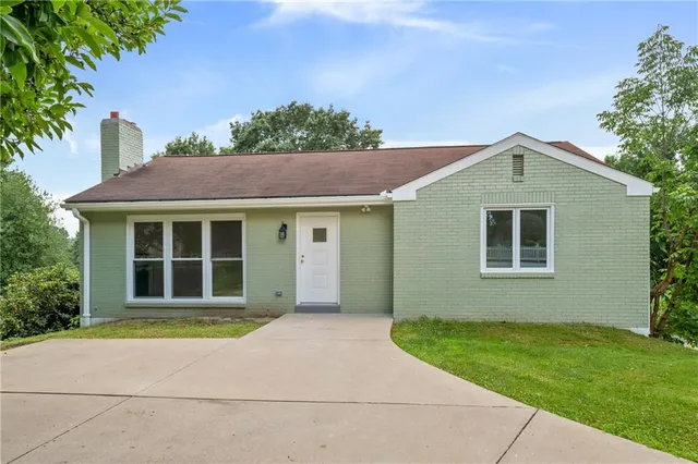 a front view of a house with a garden and yard