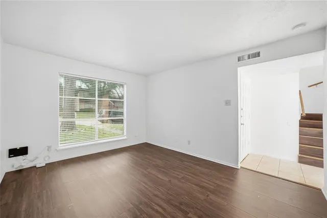 an empty room with wooden floor and window