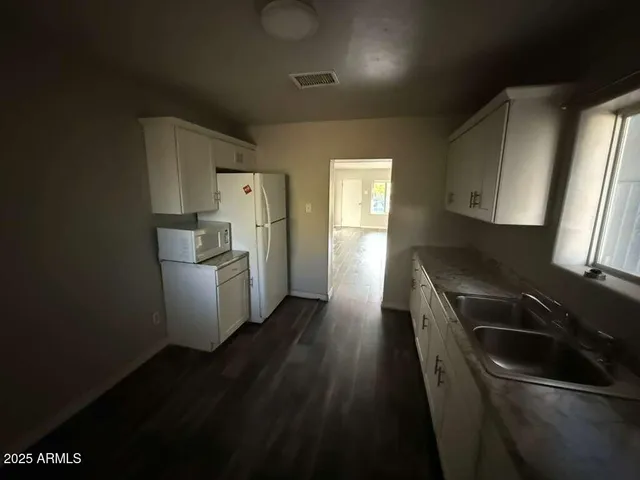 a kitchen with a sink a refrigerator and window
