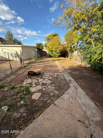 a view of a yard with wooden fence