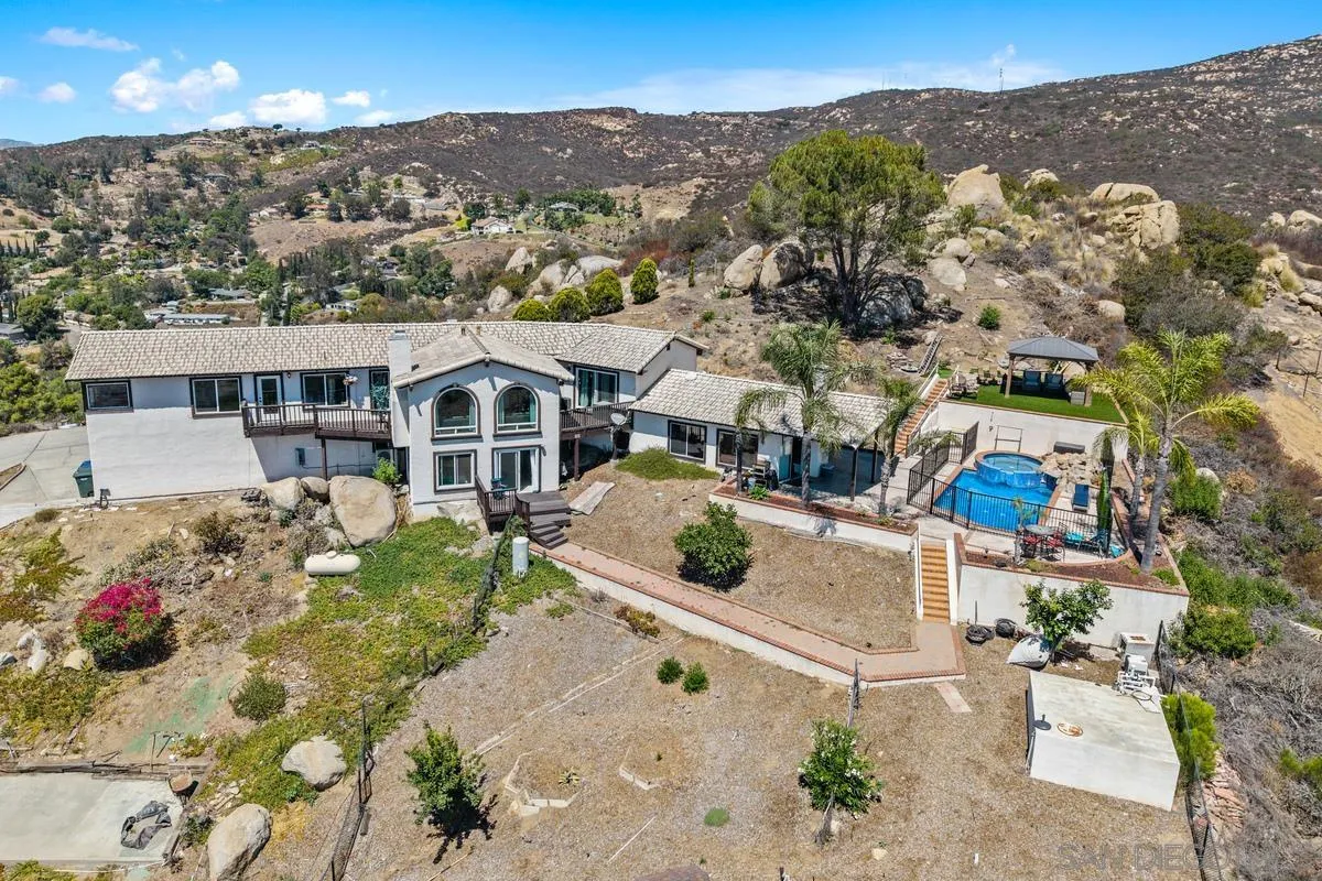 an aerial view of a house with a mountain