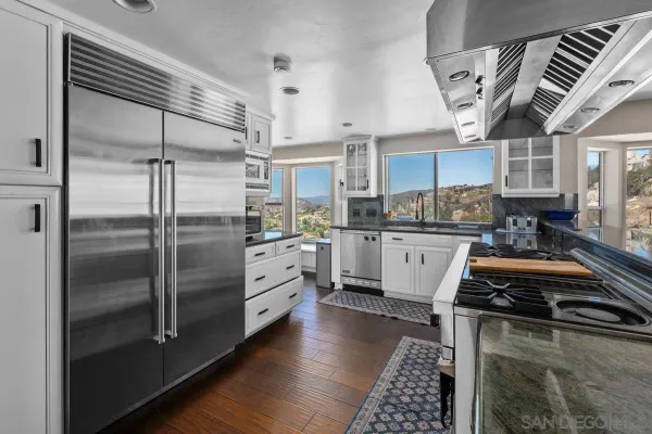 a kitchen with granite countertop a stove a sink and a cabinets
