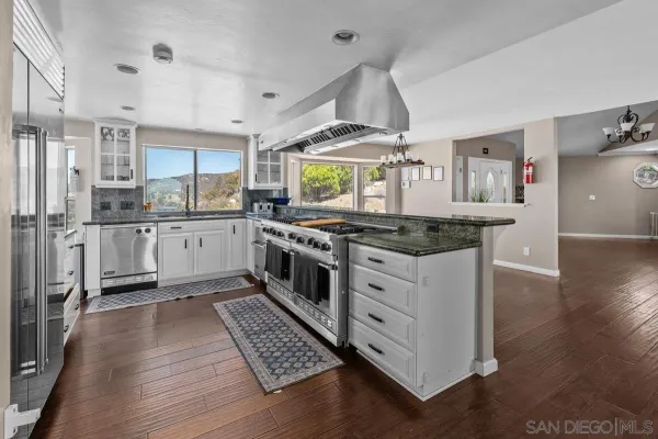 a kitchen with granite countertop a stove and a wooden floor