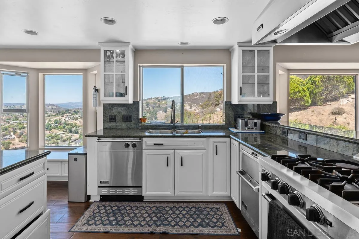 2155 Vista Valley Rim Place El Cajon, CA 92019 - Photo 19 of 61 a kitchen with granite countertop a stove a sink and a cabinets