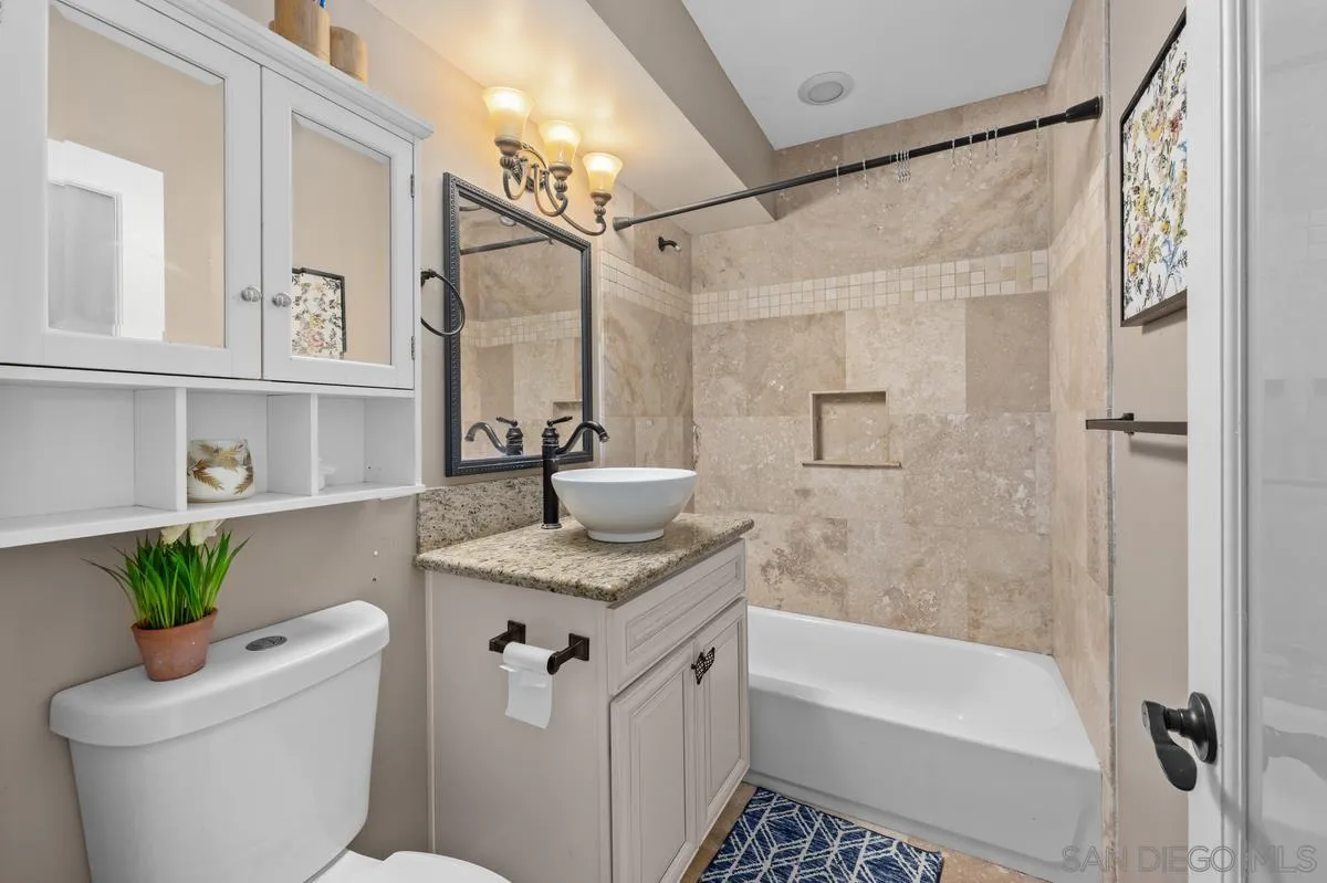 2155 Vista Valley Rim Place El Cajon, CA 92019 - Photo 26 of 61 a bathroom with a granite countertop sink a toilet a mirror a bathtub and shower