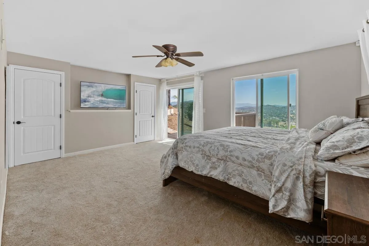 2155 Vista Valley Rim Place El Cajon, CA 92019 - Photo 28 of 61 a spacious bedroom with a bed and a chandelier