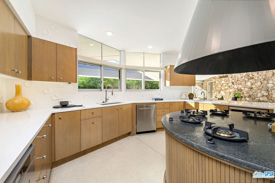 1350 Ladera Circle Palm Springs, CA 92262 - Photo 21 of 54 a kitchen with sink a stove and chairs