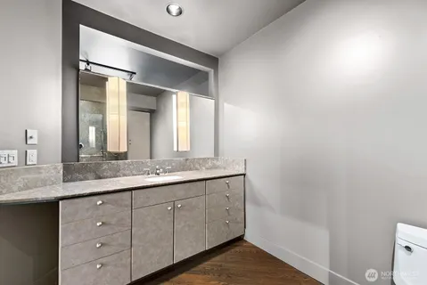 a bathroom with a granite countertop sink and a mirror