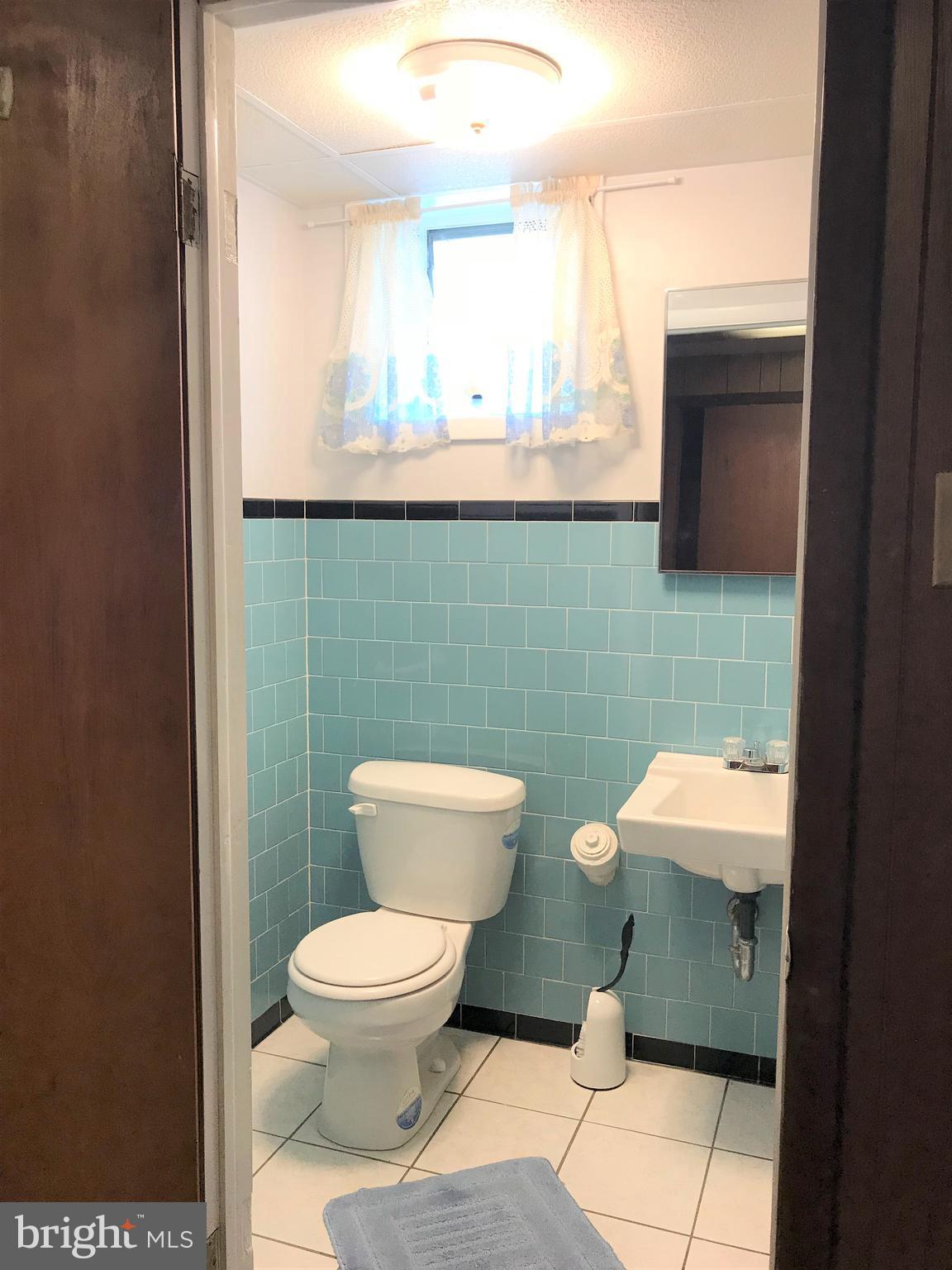 2306 Ruth Avenue Baltimore, MD 21219 - Photo 17 of 19 a bathroom with a toilet a sink and mirror