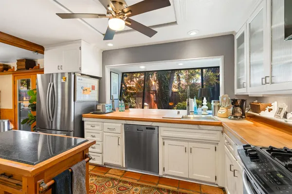 a kitchen with stainless steel appliances granite countertop a sink a stove and a refrigerator